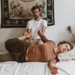 A peaceful Thai massage session with a woman being gently stretched by a therapist in a tranquil setting.
